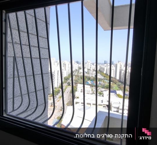 סורגים עם בטן מברזל כהה המותקנים על חלון דירה
